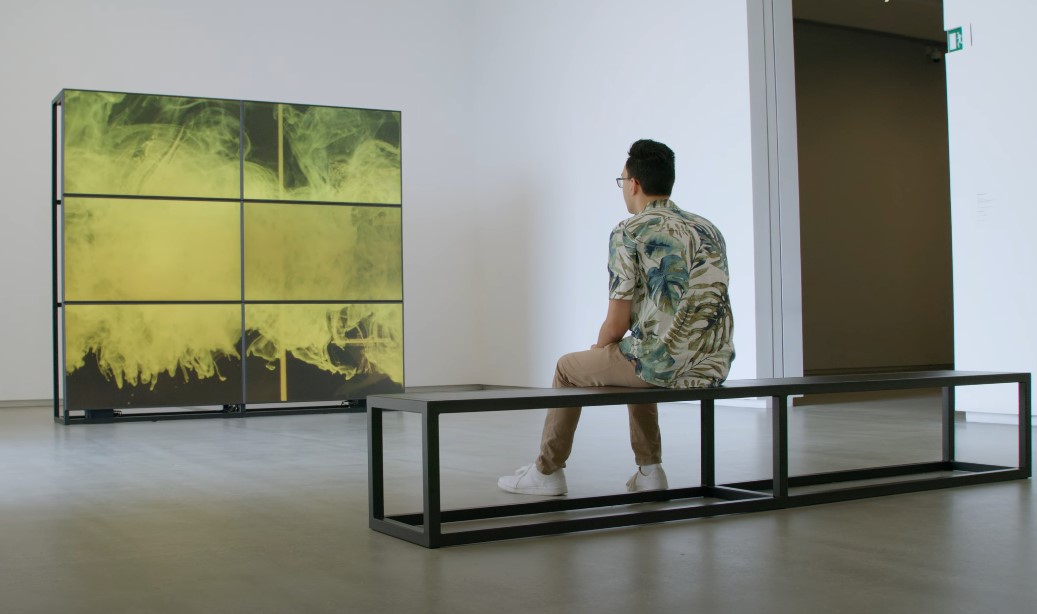 Person sitting in front of an artwork