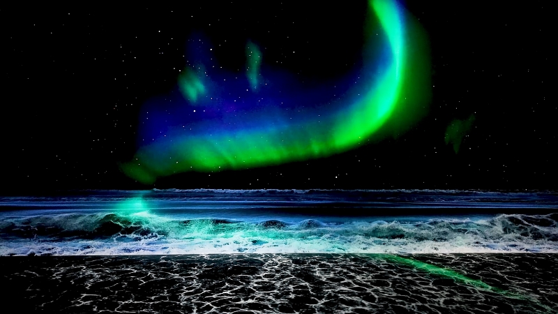A digital art display at ARTE MUSEUM Las Vegas shows vivid green and blue aurora over a dark ocean scene
