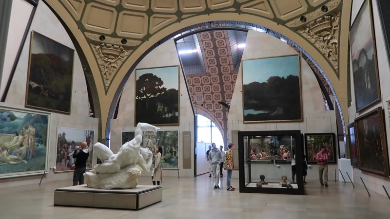Visitors view large paintings and sculptures inside the ornate gallery of the Musée d’Orsay in Paris