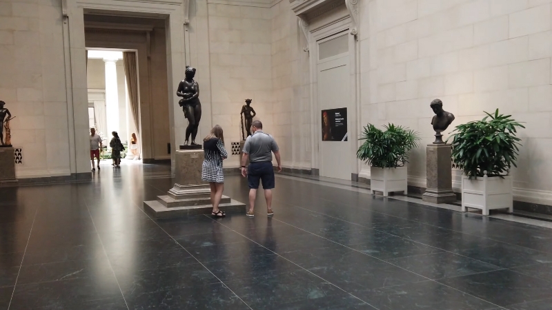 Visitors view classical sculptures in a spacious gallery at the National Gallery of Art in Washington, D.C